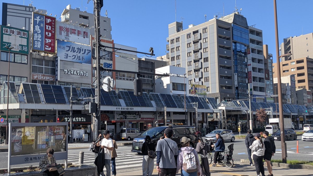 駅前の商店や歩行者が見える街の風景